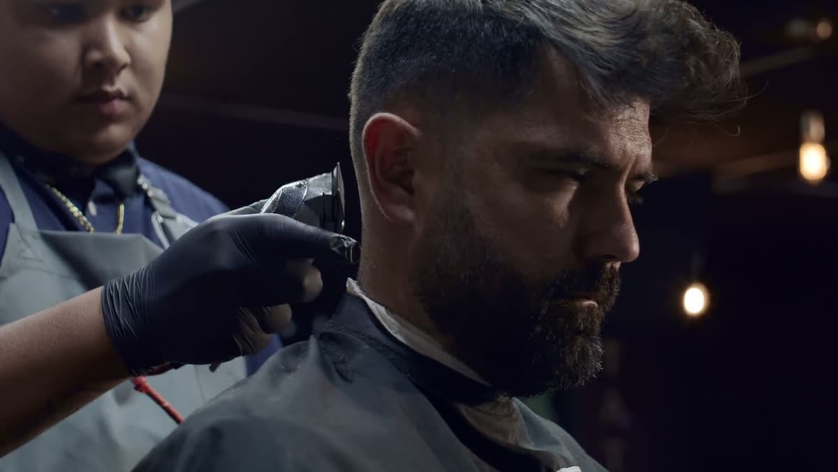 Barber working a clipper along a client's neckline